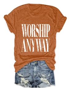 Flat lay of an orange crew neck t-shirt with Worship Anyway print and denim shorts