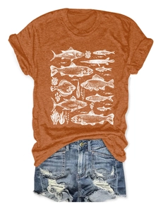 Flat lay of a summer orange T-shirt with white fish graphics and ripped denim shorts