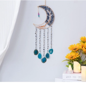 Dettaglio decorazione murale luna boho con fette di agata blu e cristalli naturali