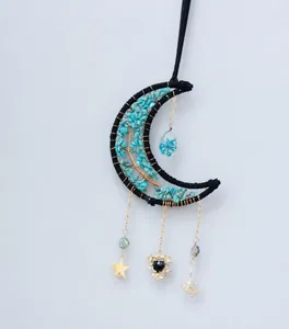 Détail d'un attrape-rêve lune avec pierres bleues, arbre d'or et charms d'étoile