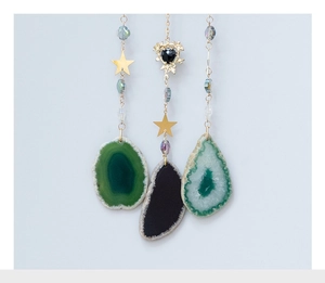 Détail du pendentif arbre de vie en agate avec chaîne dorée et ornements d'étoiles