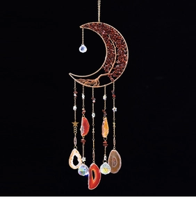 Détail d'attrape-soleil arbre de vie avec pierres rouges, tranches d'agate et boules de cristal