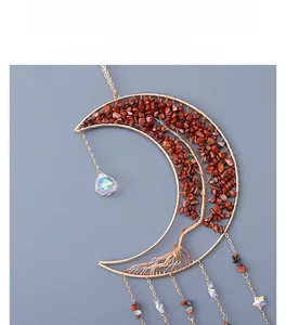 Détail d'un attrape-soleil lune arbre de vie doré avec pierres rouges et cristaux