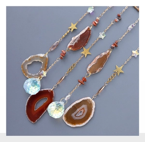 Gros plan sur des tranches d'agate rouge et pendentifs en cristal de jardin