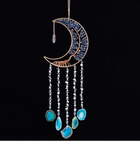 Dettaglio dell'acchiappasogni a luna con fette di agata blu e design albero della vita