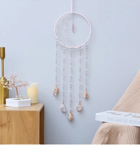 Détail d'un attrape-rêves Arbre de Vie rose avec filet tissé et pendentifs en pierres