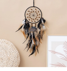 Detail eines böhmischen Traumfängers mit Naturachat und Federn an einer Wand hängend