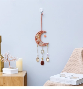 Moon-shaped woven suncatcher with orange stones and hanging crystals for wall decor