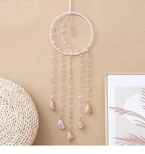 Détail d'un attrape-rêve arbre de vie rose avec pierres enroulées et glands perlés