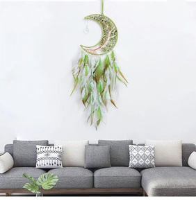 Moon-shaped dream catcher with tree of life stones and feathers hanging on wall