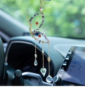 Detail view of handmade butterfly car charm with purple crushed stone and crystal hearts