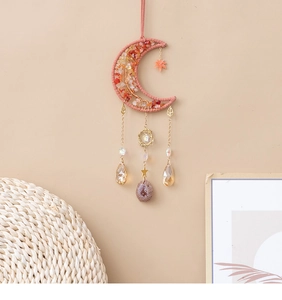 Handwoven moon-shaped wall hanging with red crushed crystals and metallic chains