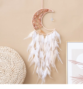 Detail of pink crystal tree of life dreamcatcher with soft white feathers on a wall