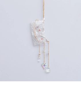 Detailed view of handmade butterfly suncatcher with purple crystals and heart pendant