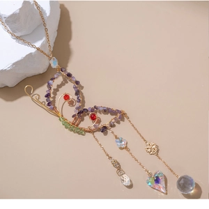 Detail of handmade gold wire butterfly crystal suncatcher with purple stones and beads