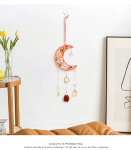 Detail of moon-shaped wall hanging with red crystal stones and faceted glass pendants