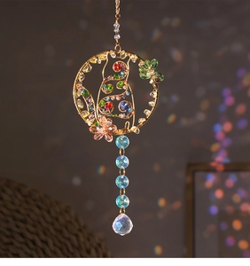 Close-up of handmade cat suncatcher with crystals and colorful stone accents