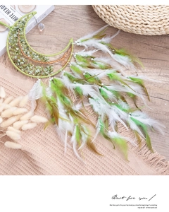 Detail of bohemian moon dream catcher with green crystal tree of life and soft feathers
