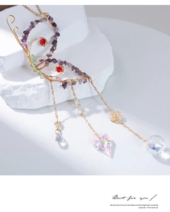 Close-up of golden butterfly wire-wrapped suncatcher with colorful crystals and stones