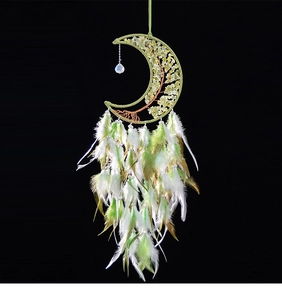 Detail of moon dreamcatcher with tree of life crystal stones and soft green feathers
