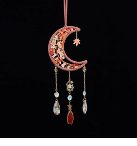 Macro detail of moon-shaped woven wall hanging with red stones and golden pendants