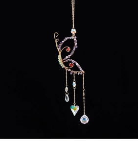 Detail of butterfly suncatcher with colorful crystals and hanging metal chains