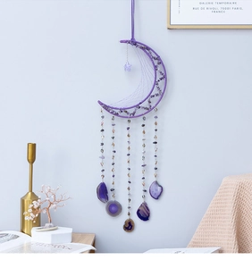 Detail of purple moon dreamcatcher with amethyst stones and hanging agate slices