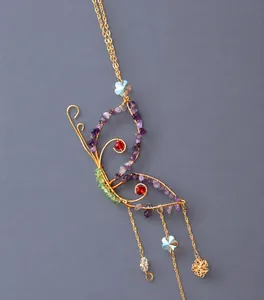 Detailed wire-wrapped butterfly pendant with purple crystals and starry accents