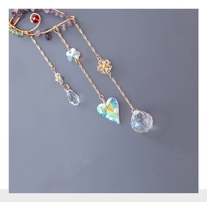 Close-up of golden butterfly suncatcher with crystal teardrops and colorful stones