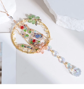 Macro shot of handmade crystal suncatcher with golden wire and colorful faceted beads