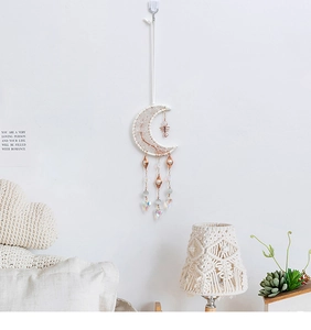 Detail of moon-shaped woven dreamcatcher with crystal heart and beads for home decor