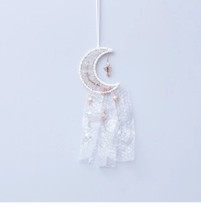 Detail of moon-shaped suncatcher with white lace ribbons and sparkling crystal beads