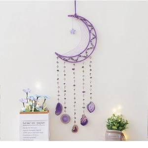 Detail of a purple moon dream catcher with natural crystal stones and amethyst slices