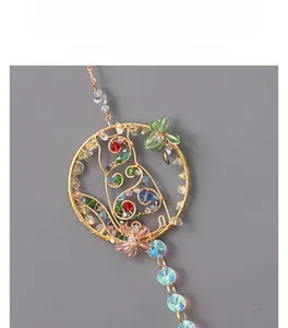 Detail of handmade woven gold wire pendant with colorful crystal beads and floral design