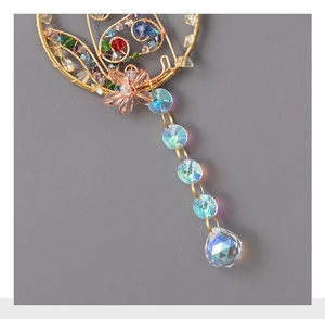 Macro view of handmade wire-wrapped crystal suncatcher with colorful beads and flower