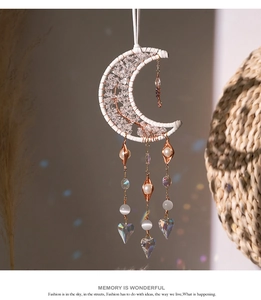 Detail of moon sun catcher with tree of life crystals and rainbow light refraction