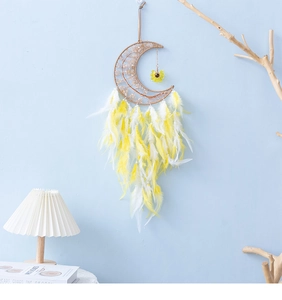 Detail of moon-shaped dream catcher with yellow feathers and sunflower charm