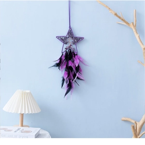 Detail of purple star dreamcatcher with tree of life crystals and feathers on blue wall
