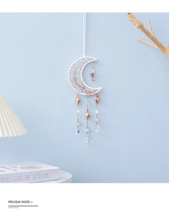 Detail of moon-shaped suncatcher with white woven frame and crystal stone pendants