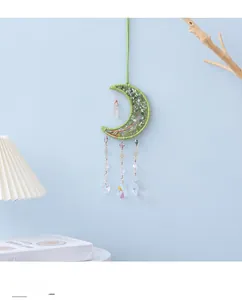 Detail of brass crescent moon with green gemstone tree of life and crystal suncatcher drips