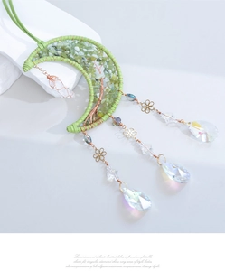 Detail of moon suncatcher with green crystal tree of life and hanging prism drops