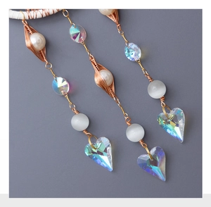 Close-up of tree of life suncatcher with iridescent heart crystal and wire wrapping
