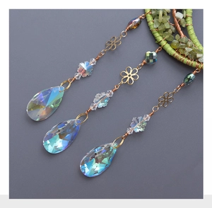 Detail of brass suncatcher with green crystal ring and rainbow reflecting drop prisms