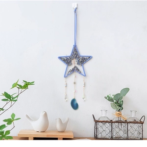 Acchiappasogni stella albero della vita blu con prismi di cristallo su muro bianco