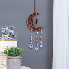 Detail of moon-shaped crystal wall hanging with tree of life and colorful snowflake charms