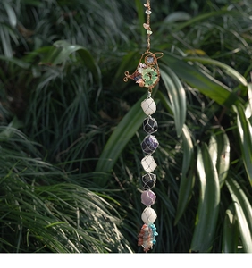 Detailed view of handmade crystal stone tree life hanging decor with bohemian tassels