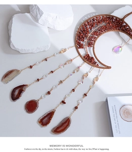 Detailed view of handmade moon dreamcatcher with red stone tree of life and agate slices