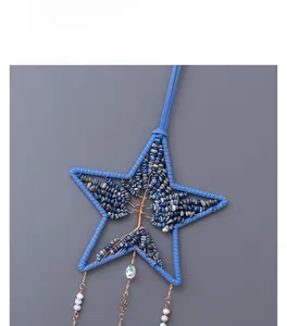 Dettaglio macro del ciondolo a stella albero della vita con cristalli blu e filo metallico