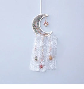 Dettaglio dell'acchiappasogni a forma di luna con cristalli dell'albero della vita