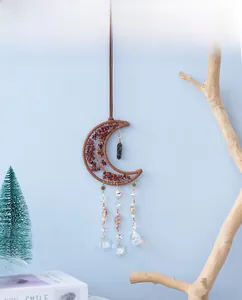 Detailed view of crescent moon crystal hanging decor with brown woven frame and gemstones